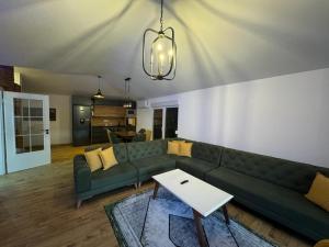 a living room with a green couch and a table at Villa B in Gnjilane