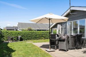 a table with an umbrella on a patio at 40116-Juelsminde-Mirabellevej-10 in Juelsminde