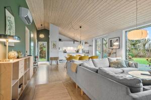 ein Wohnzimmer mit großer Couch und Küche in der Unterkunft 30369 Odder - Rude Hedevej 15 in Odder