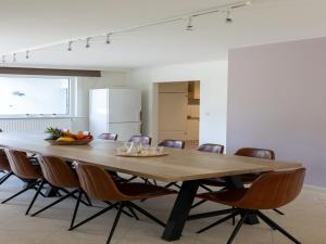 a dining room with a wooden table and chairs at Heated Pool & Beach Access in Koksijde +32 photos
