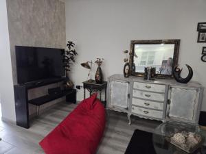 a living room with a red couch and a mirror at Casa da Praceta in Torres Vedras