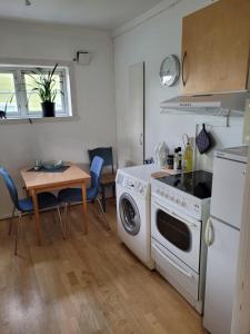 a kitchen with a washing machine and a table at Hybelleilighet - Privat - no parking in Tromsø