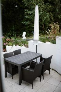 a black table and chairs with a white umbrella at Exklusive Ferienwohnung mit Privatterrasse in Plön +17 photos