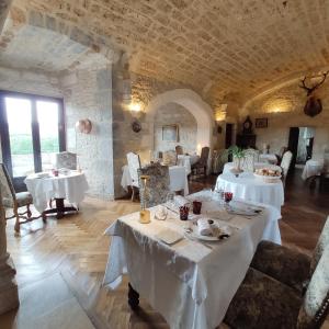a dining room with white tables and chairs at Château Hôtel La Terrasse - Teritoria in Meyronne +52 photos
