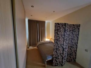 una camera con un letto e una finestra con una tenda di 2-room apartment in the house with the SEPARATE ENTRANCE & FREE parking a Riga