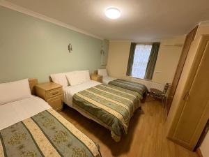 Una cama o camas en una habitación de Carlton Hotel annexe 8 fotos más