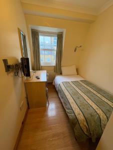 Una cama o camas en una habitación de Carlton Hotel annexe