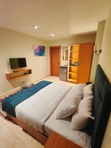a bedroom with a large bed with pillows at Kush Hotel, Grand Museum & Pyramids View in Cairo