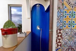 a blue shower in a bathroom with a window at Celebrity Suite - Big Terrace on the Sea in Praiano