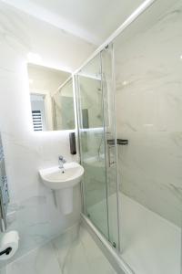 a white bathroom with a sink and a shower at Centra High Road in London