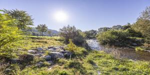 ein Fluss mit Felsen und der Sonne am Himmel in der Unterkunft HOKK Hotel im Sportpark in Freiburg im Breisgau + 15 Fotos