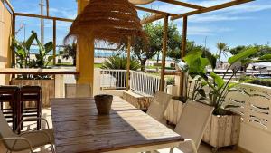a wooden table and chairs on a patio at BeachFront Apartment in Gandia in Puerto de Gandía