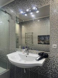 a bathroom with a sink and a mirror at Большая 2х ком in Uralsk