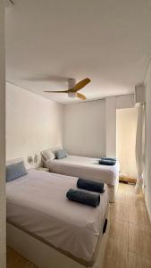 a bedroom with two beds and a ceiling fan at BeachFront Apartment in Gandia in Puerto de Gandía