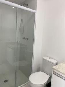 a white bathroom with a toilet and a shower at Apto ao lado do metrô de SP in Sao Paulo