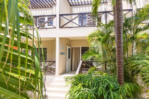 an external view of a building with palm trees at Blenchi Apartments Curacao in Willemstad