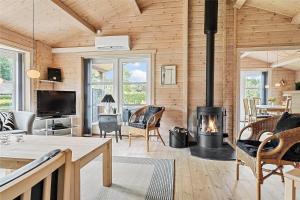 un soggiorno con camino in una casa di legno di 40505-Juelsminde-Pot-Strandby-326 a Sønderby