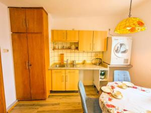 a kitchen with wooden cabinets and a table and a microwave at Pension bei Goscha mit Schlossblick in Braunfels