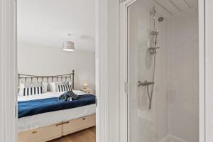 a bedroom with a bed and a walk in shower at Polmont Haven: Spacious 4- Bedroom Retreat in Polmont