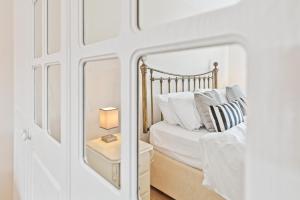 a white bedroom with a bed with a mirror at Polmont Haven: Spacious 4- Bedroom Retreat in Polmont +28 photos