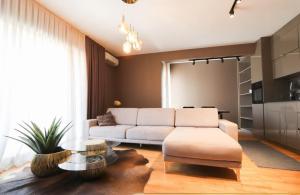 a living room with a white couch and a table at Ultra Luxurious Apartment in Laplje Selo