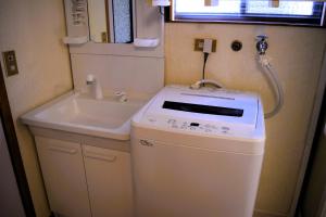 a small bathroom with a sink and a washing machine at Suzuri硯 in Takayama