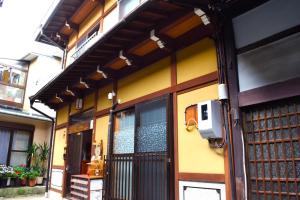 a yellow building with a door with a pay phone on it at Suzuri硯 in Takayama