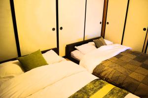 two beds sitting next to each other in a room at Suzuri硯 in Takayama