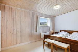una camera da letto con un letto e una parete di legno di 30579-Odder-Dyngby-Havvej-5 a Odder