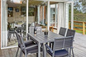 un tavolo e sedie in legno su un portico di 30579-Odder-Dyngby-Havvej-5 a Odder