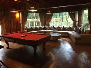 a living room with a pool table in the middle at Cabaña del RIO by Bellavista Cabañas in Mazamitla