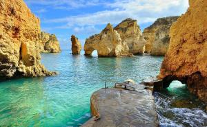 a body of water with rocks in the water at Vilamar in Luz