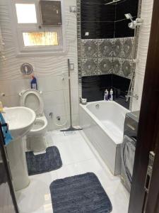 a bathroom with a toilet and a tub and a sink at اكتوبر الحصري 6 October in 6th Of October +24 photos