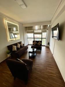 a living room with a couch and a table at Moderno Depto Av América 2 habitaciones in Cochabamba