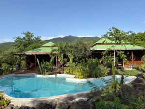 a swimming pool in front of a resort at Villa Ti Colibri in Bouillante