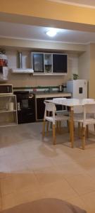 a kitchen with a table and two white chairs at Amplio monoambiente céntrico Rafaela in Rafaela +6 photos