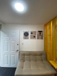 ein Wohnzimmer mit einem Sofa und einer weißen Tür in der Unterkunft 313Apartaestudio del cedro in Bogotá
