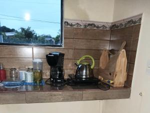 a counter with a coffee maker and a tea kettle at La casita de Miguel in Villarrica
