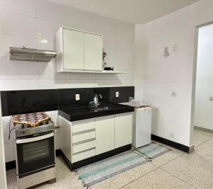 a kitchen with white cabinets and a sink at Entre Voos in Pedro Leopoldo +10 photos