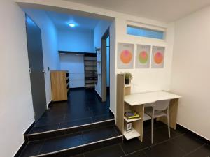 ein Zimmer mit Schreibtisch und ein Flur mit Küche in der Unterkunft 313Apartaestudio del cedro in Bogotá