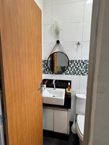 a bathroom with a sink and a mirror and a toilet at Entre Voos in Pedro Leopoldo