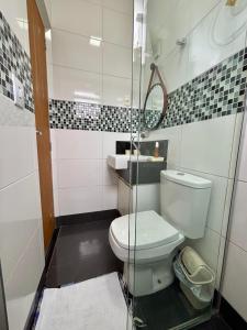 a bathroom with a toilet and a glass shower at Entre Voos in Pedro Leopoldo