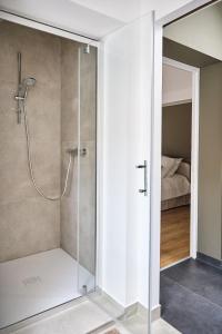 a shower with a glass door in a bathroom at GITE de LA COUR DES CHASSEURS in La Wantzenau