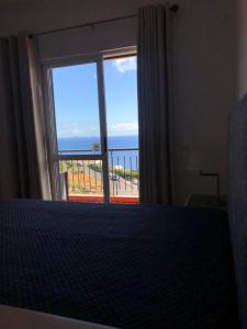 una camera da letto con un letto e vista sull'oceano di Sunshine Room a Gaula
