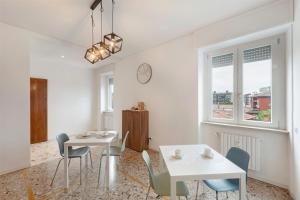 comedor con 2 mesas y sillas y reloj en Locanda Enzina, en Bérgamo