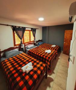 a room with three beds in a room at La Tía Rola in Humahuaca