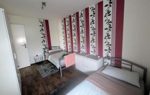a small room with two beds and red and white walls at Ferienwohnung Familie Perl in Immenhausen