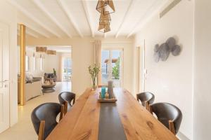 a dining room with a wooden table and black chairs at Blue Diamond BESTOFMIKONOS in Ornos