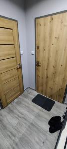 a bedroom with a bed and a wooden door at Karola Szymanowskiego 2 Apart in Chełm