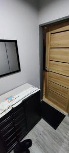 a room with a wooden door and a chair in front of it at Karola Szymanowskiego 2 Apart in Chełm